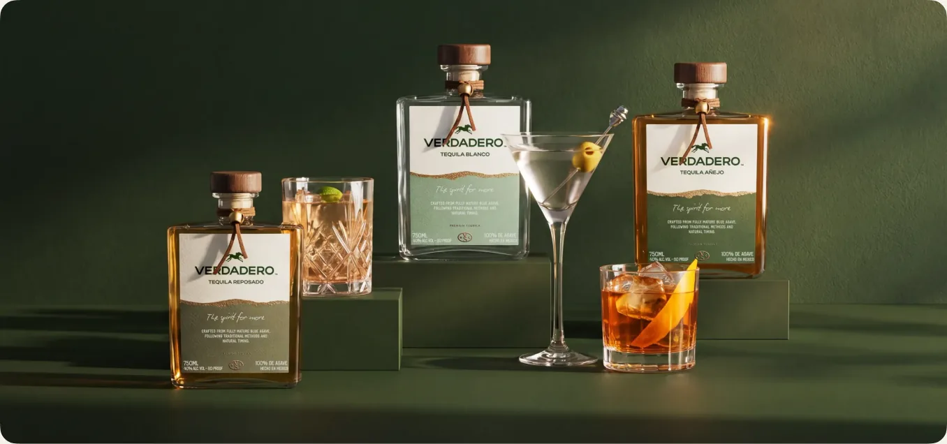 A lineup of Verdadero tequila bottles and mixed cocktails styled on a floral backdrop