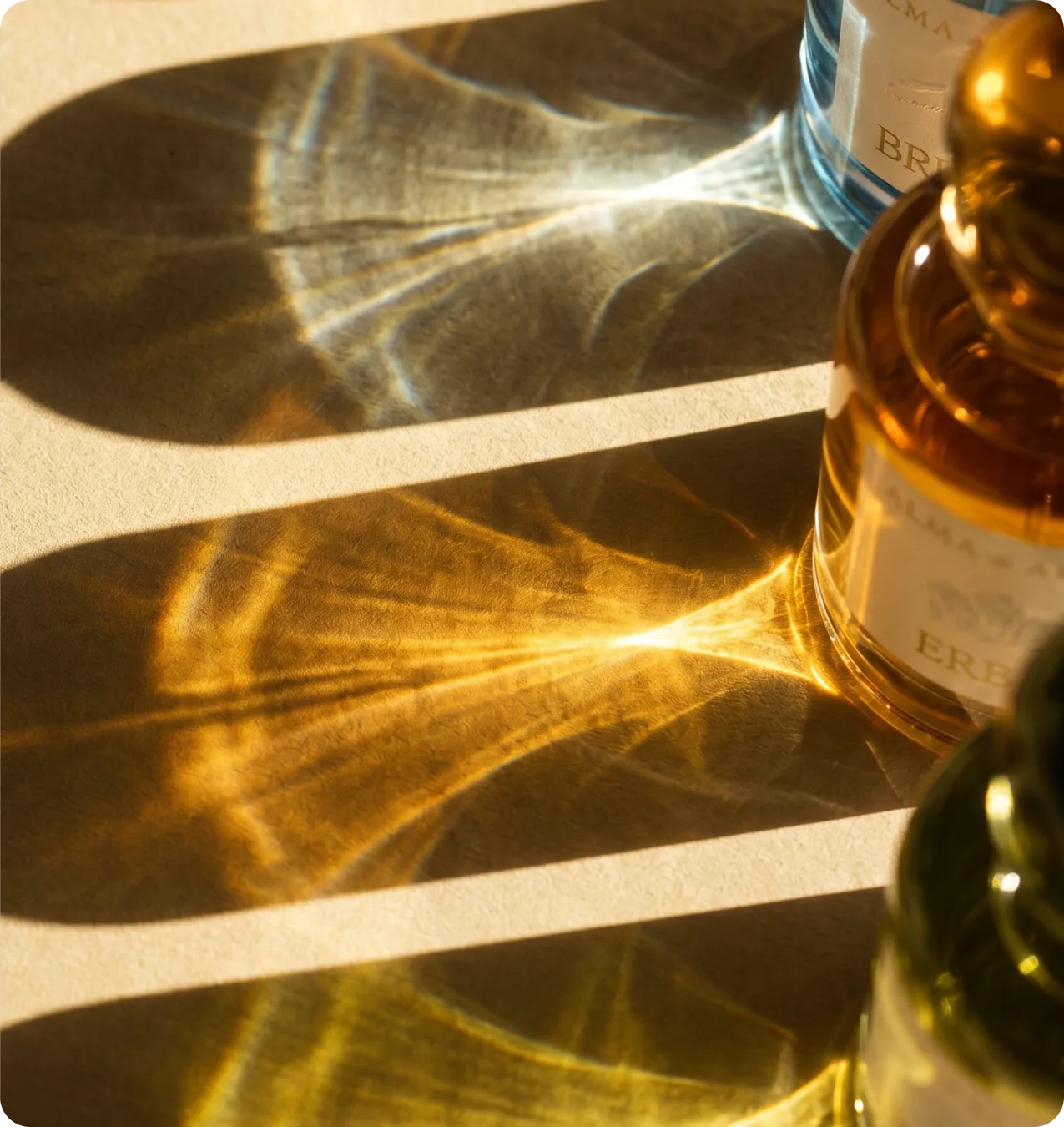 Alma di Alba — flat-lay composition of the ERBA and BRUMA bottles under caustic sunlight patterns