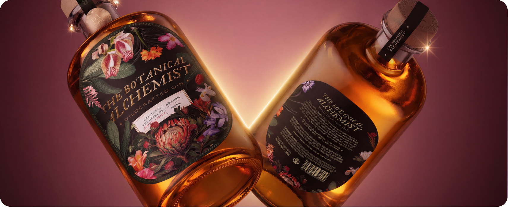 The Botanical Alchemist — two wildcrafted gin bottles converging on a deep red and pink gradient backdrop, showcasing the brand's botanical-illustrated front label and minimalist back label