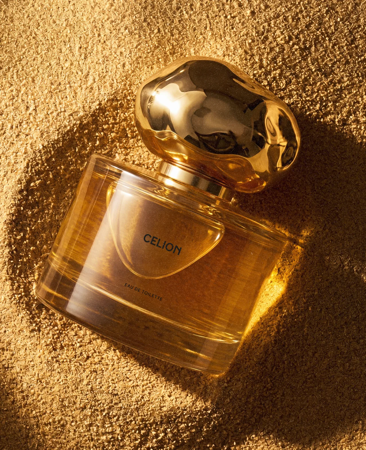 Celion — the perfume bottle resting on golden desert sand