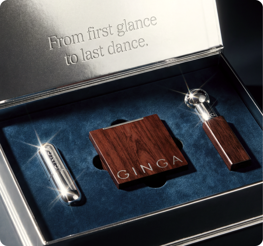 Ginga — open luxury gift box engraved 'From first glance to last dance,' holding the chrome lipstick, wood-veneer compact, and applicator on velvet
