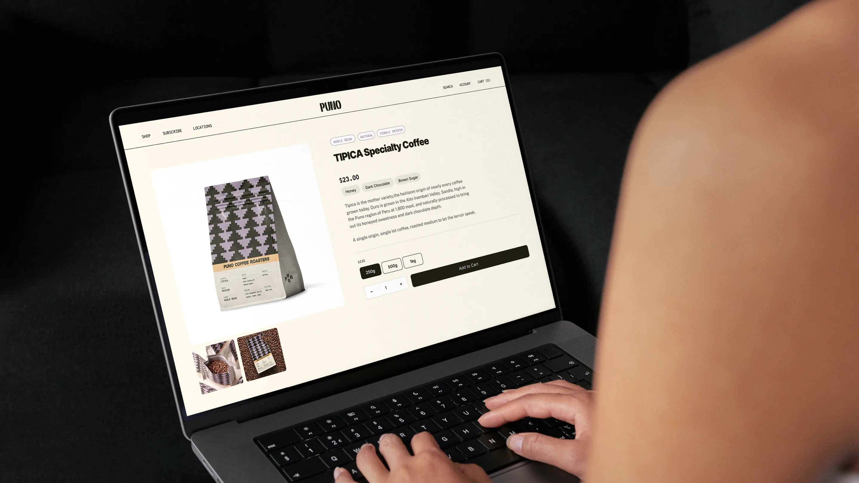 Puno — a person on a dark sofa working on a MacBook that shows the Puno TIPICA Specialty Coffee product page, with the pyramid-patterned coffee bag mockup on the left, 250g / 500g / 1kg size selector, and an 'Add to Cart' button