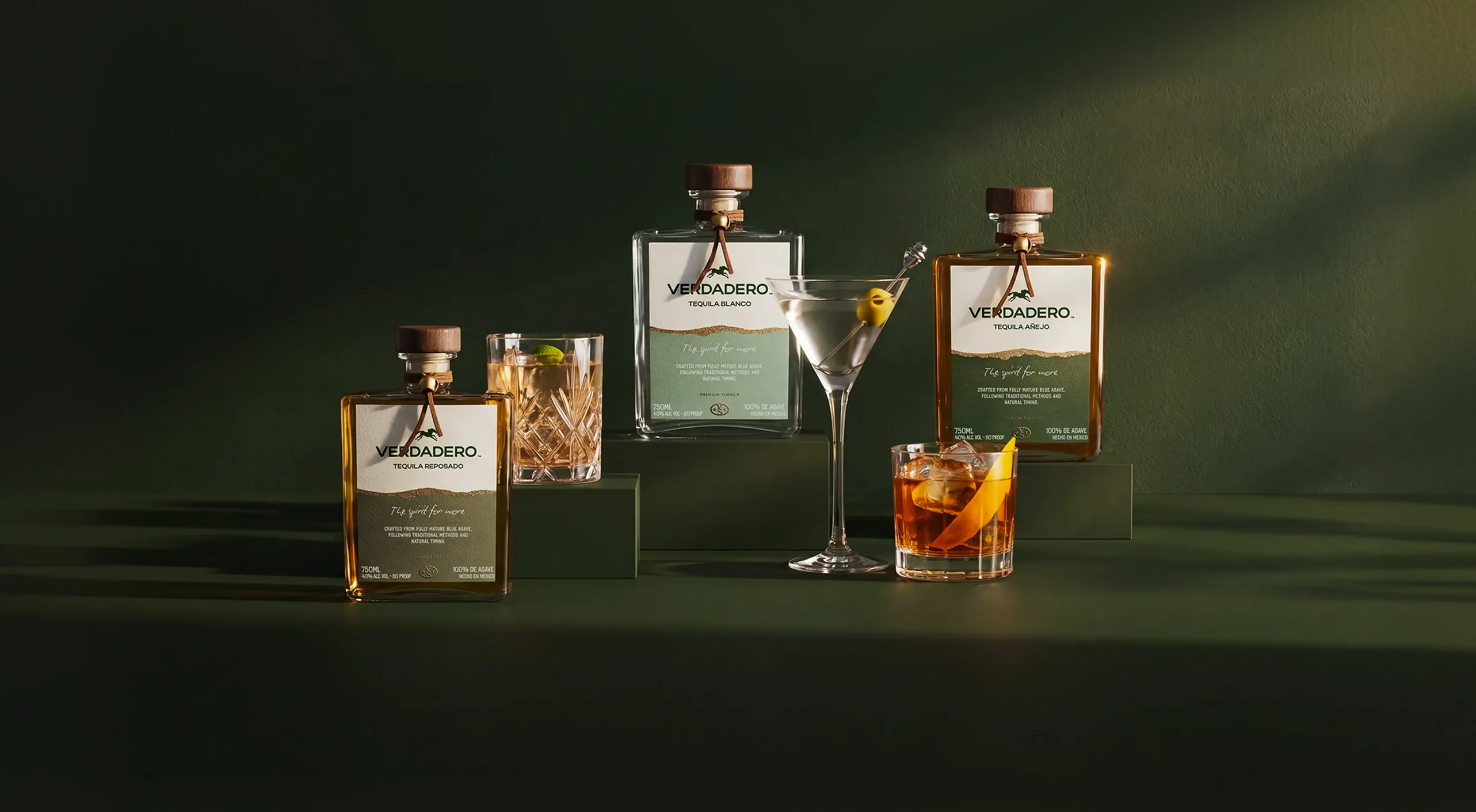 Verdadero — the three-bottle lineup with signature cocktails on a deep green set