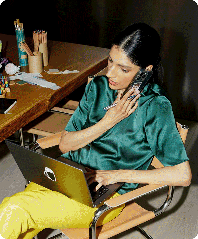 Creative professional working at desk with laptop and phone