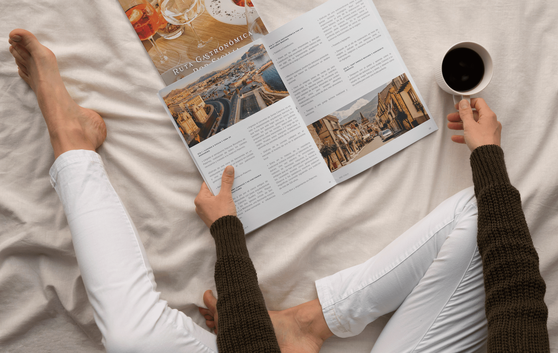 Person reading an informative magazine in about Italy sitting in bed while drinking a coffee