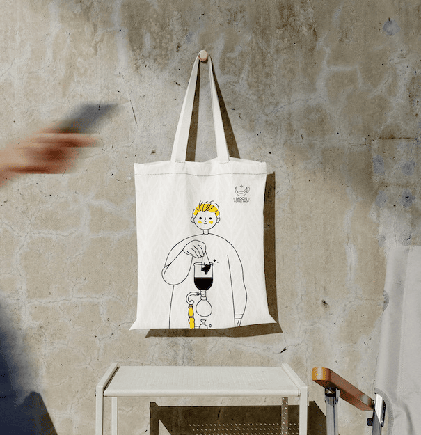 tote bag with guy ilustration hanging on the wall